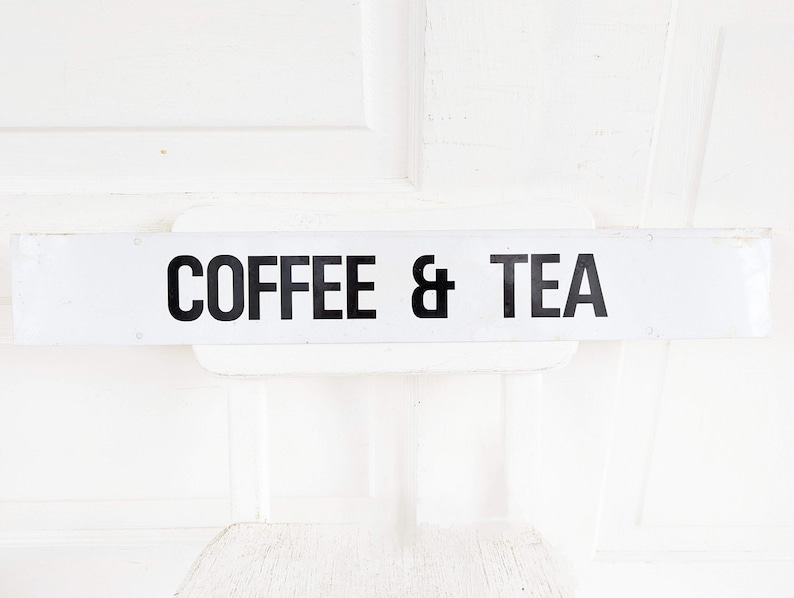 Puede incluir: Un letrero rectangular blanco con texto negro que dice "COFFEE & TEA".