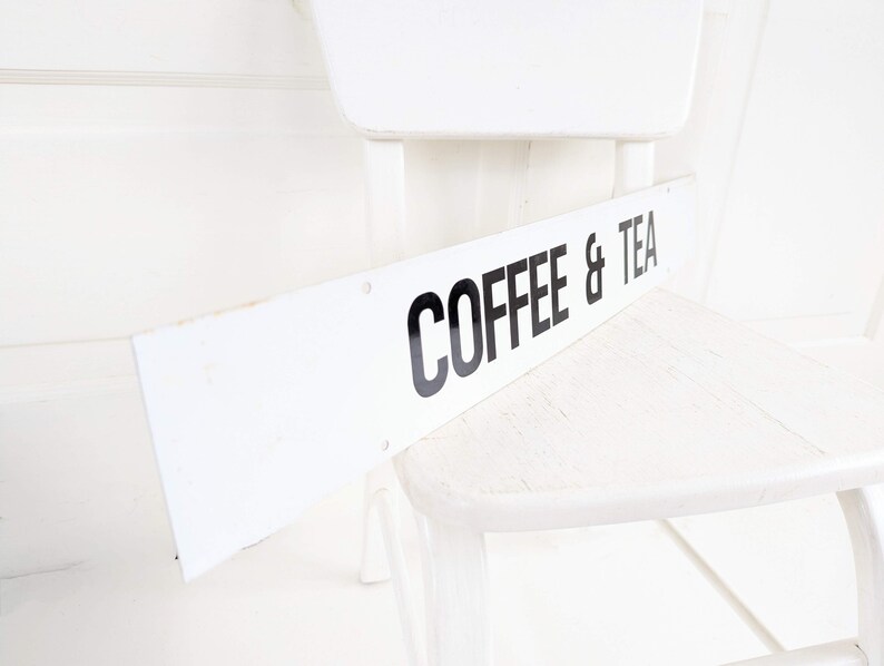 Puede incluir: Silla de madera blanca con un letrero blanco que dice "COFFEE & TEA".
