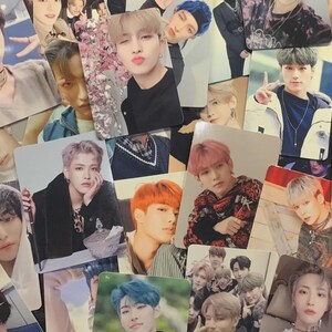 May include: A collection of rectangular photo cards featuring various portraits of a young person with diverse hair colors, including black, pink, orange, and blue, captured in different poses, outfits, and settings, layered together in a dense collage.