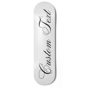 May include: A white skateboard featuring the words "Custom Text" in black cursive lettering. The board has a rounded shape. The text is written vertically down the centre of the board.