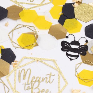 May include: Gold and black confetti with a bee and a hexagon with the text "Meant to Bee".