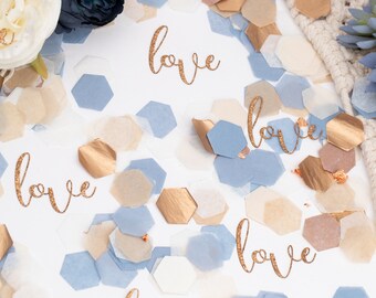 Pode incluir: Confetti azul, branco e dourado com a palavra "love" escrita em glitter dourado sobre um fundo branco.