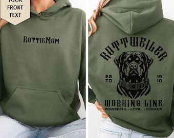 May include: An olive green hooded sweatshirt featuring the black text RottiMom on the front. The back displays a black graphic of a Rottweiler dog head with the text Rottweiler, Estd 1910, Working Line, Powerful, Loyal, Steady printed in black.