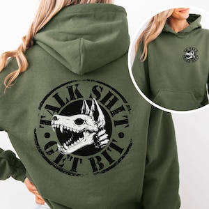 May include: Olive green hoodie with a large graphic on the back featuring a dog skull and the text "TALK SHIT GET BIT" in a circular design. The front of the hoodie has a smaller graphic with the same dog skull and text "NO TALK SHIT GET BIT".