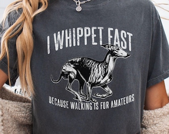 May include: Dark gray t-shirt with the text "I Whippet Fast" above a black and white graphic of a running whippet dog. The text "Because walking is for amateurs" is below the dog.