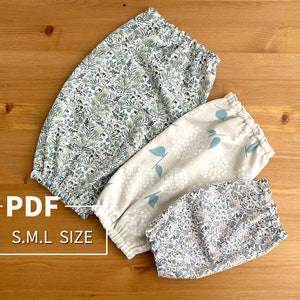 Puede incluir: Tres pares de calentadores de piernas de tela con diferentes patrones florales. Los calentadores de piernas están hechos de tela suave y elástica y están disponibles en tallas pequeña, mediana y grande. El texto "PDF S.M.L SIZE" está impreso en la superficie de madera.