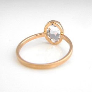 Op de afbeelding: Een verlovingsring met een roosgeslepen diamant, gezet in een gouden band. De ring wordt van de zijkant getoond, met de diamant naar de camera gericht.