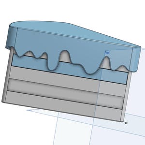 Puede incluir: Un pastel azul y gris con glaseado azul que gotea por los lados. El pastel tiene forma de rebanada y tiene una etiqueta "Front" en la parte superior.
