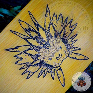 May include: A black and white illustration of a sea creature with a spiky, crown-like head on a light brown wooden surface. The image is surrounded by text that reads "Battle Crafting Norse Saga Shield Norse Myth Viking Legacy Art".