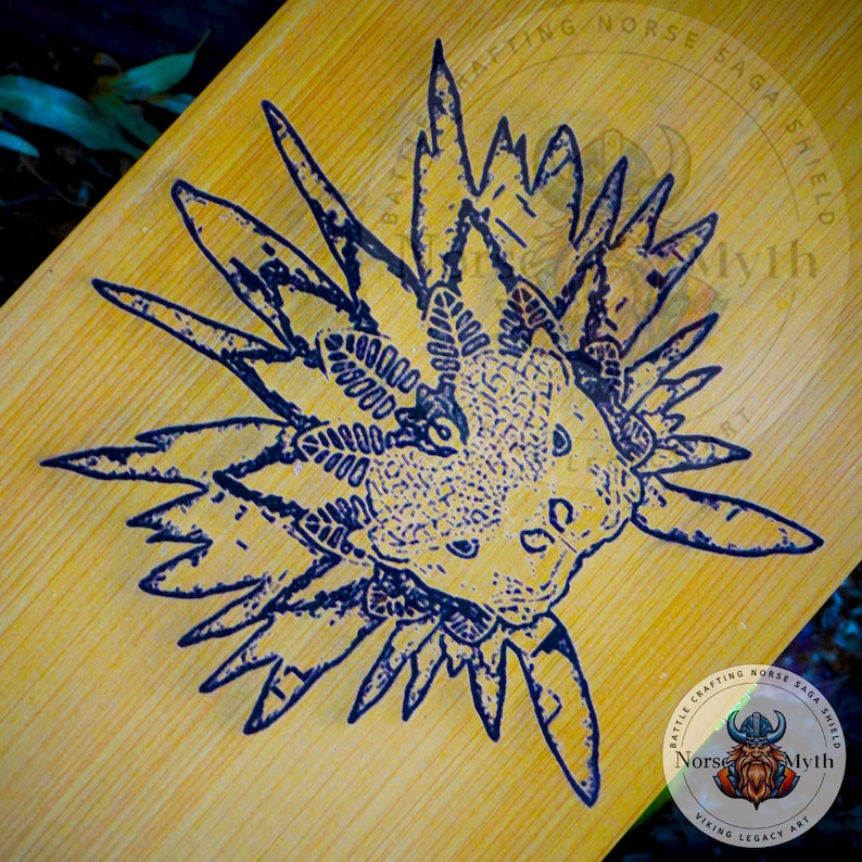May include: A black and white illustration of a sea creature with a spiky, crown-like head on a light brown wooden surface. The image is surrounded by text that reads "Battle Crafting Norse Saga Shield Norse Myth Viking Legacy Art".
