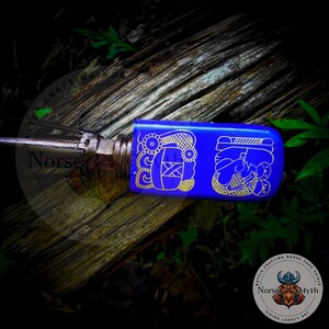 May include: A blue and gold decorative knife handle with intricate designs. The handle is made of wood and has a blue finish with gold accents. The design on the handle is a stylized representation of a Viking ship.