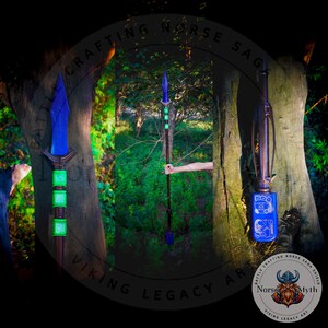 May include: Three blue and green spears with intricate designs. The spears are made of wood and metal and have a sharp point. The spears are displayed against a backdrop of trees.