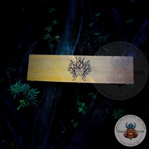 May include: A wooden box with a black and white illustration of a creature with a crown of spikes. The box is labeled "Norse Myth" and "Viking Legacy Art".