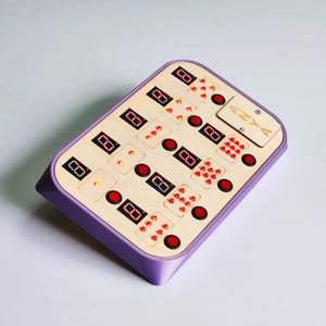 Puede incluir: Un tablero de juego rectangular de madera con un marco morado. El tablero presenta pantallas digitales rojas, botones circulares rojos y pequeños puntos rojos. La palabra "ANYA" está grabada en una pequeña sección de madera.