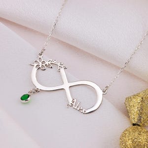 Peut inclure: Collier infini en argent avec un motif floral et un pendentif en pierre verte. Le nom "Alex" est inscrit sur le collier.