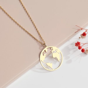 Collier en or élégant avec pendentif carte du monde, une pièce intemporelle symbolisant l'unité du monde, les rêves de voyage et l'envie d'errer