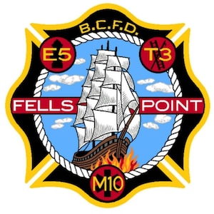 Könnte beinhalten: Ein schwarzes und gelbes Feuerwehr-Abzeichen mit einem roten Seilrand. Das Abzeichen zeigt ein weißes Schiff mit einem rot-weißen Segel, ein rotes Banner mit dem Text "FELLS POINT" und einen roten Kreis mit dem Text "E5".