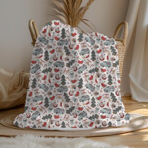 May include: A white throw blanket with a repeating pattern of Christmas trees, candy canes, stockings, pizza boxes, and a vintage van. The pattern is in shades of red, green, and blue.