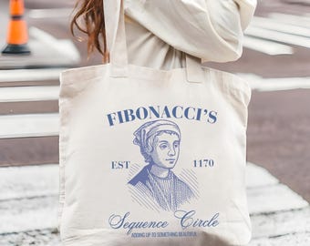 May include: Off-white tote bag with a blue illustration of a person and the text "FIBONACCI'S", "EST 1170", and "Sequence Circle". The bag has two handles and is made of a sturdy fabric.