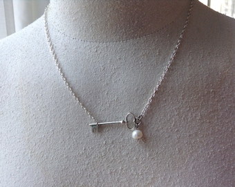 Collier clé squelette sur le côté avec une perle