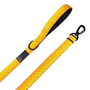 May include: A dog leash featuring a vibrant yellow and orange gradient pattern with small white triangles throughout. The leash includes a black handle lining, a black metal D-ring, a black rectangular brand tag, and a black metal swivel snap hook.