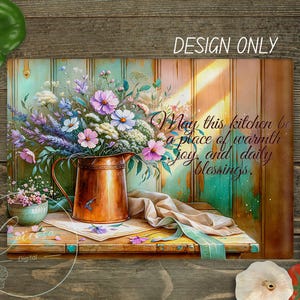 May include: A digital art print featuring a copper pitcher filled with colorful flowers, set on a wooden table. The text reads "May this kitchen be a place of warmth, joy, and daily blessings." The words "DESIGN ONLY" are also visible.