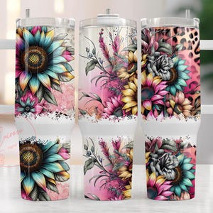 May include: Three white travel mugs with floral designs. The mugs feature colorful sunflowers, pink and yellow flowers, and a leopard print pattern. Each mug has a white handle and a clear lid.
