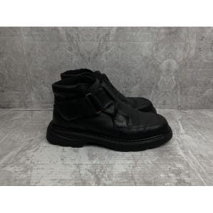 May include: Black leather ankle boots with a buckle strap and a chunky sole.