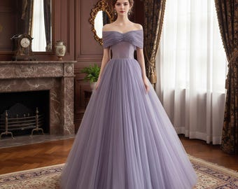Peut inclure: Une robe de bal lavande à épaules dénudées avec une jupe en tulle. Le corsage présente un motif de perles et la robe a une jupe ample et fluide. La robe convient aux événements formels.