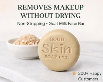 May include: A round, beige goat milk face bar with the embossed text GOOD Skin SOAP.com. Above the soap, the text reads REMOVES MAKEUP WITHOUT DRYING and Non-Stripping • Goat Milk Face Bar. A small bowl of oats sits behind the soap, and a star icon with 200+ Happy Customers is visible.