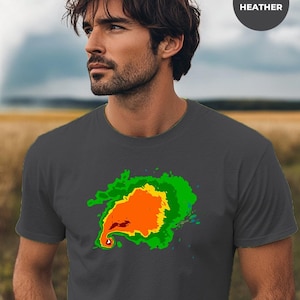 Puede incluir: Una camiseta gris oscuro jaspeada con una imagen de radar Doppler a color de un tornado.