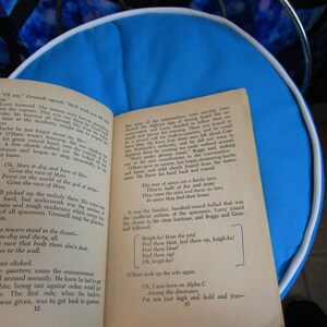 May include: A close-up of a book page with text about the race of Mars. The text reads "Oh, Mars is dry and bare of life - Gone the race of Mars. Peace on the world of the god of strife - Gone the race of Mars."