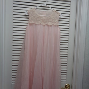 May include: A pink sleeveless nightgown with a lace trim around the neckline and hem.