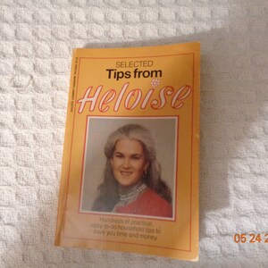 May include: A yellow book with the title "SELECTED Tips from Heloise" in red and black text. A photo of Heloise is on the cover. The text below the photo reads "Hundreds of practical, easy-to-do household tips to save you time and money".