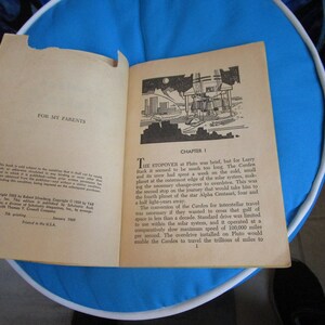 May include: A vintage paperback book titled "The Carden" with a black and white illustration of a spaceship on the cover. The book is open to the first chapter, titled "The Stopover".