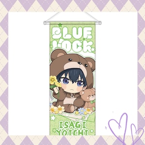 May include: A green banner featuring the text "BLUE LOCK" and "ISAGI YOICHI". The banner displays an anime-style illustration of a character in a brown bear costume holding flowers and a teddy bear.