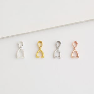 Puede incluir: Cuatro baúles de colgantes en diferentes acabados: plata, oro y oro rosa. Cada baúl es un diseño simple y elegante con un bucle en la parte superior y una abertura curva en la parte inferior.