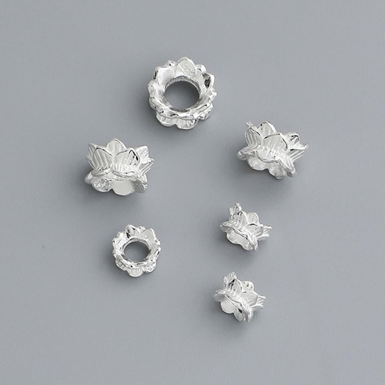 Puede incluir: Cuentas espaciadoras de plata en forma de flor para la elaboraci&oacute;n de joyas. Las cuentas tienen un delicado dise&ntilde;o floral y son perfectas para agregar un toque de elegancia a cualquier proyecto.