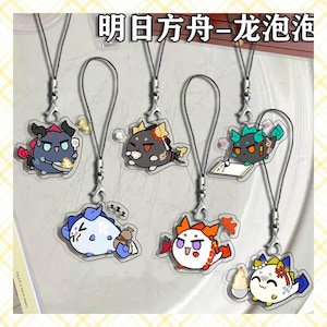 May include: A collection of acrylic charms featuring cartoon characters with various expressions. Each charm is a different color and design, attached to a silver-colored lanyard. The charms have a clear, glossy finish. The text "明日方舟-龙泡泡" is visible at the top.