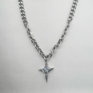 May include: A silver chain necklace with a star-shaped pendant featuring a clear crystal in the center.
