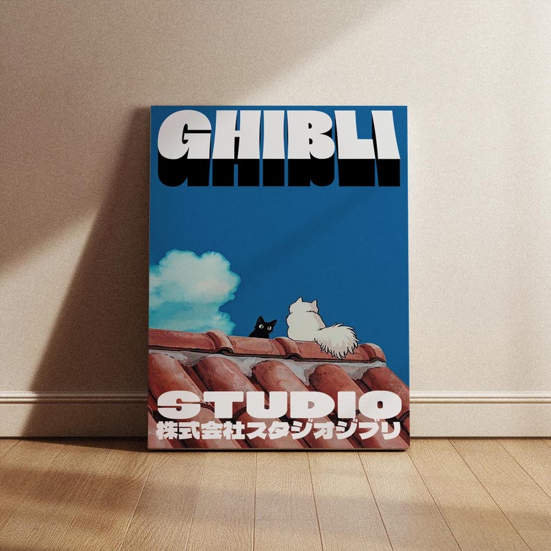 May include: A blue and white poster with the text "GHIBLI STUDIO" in black and white. The poster features two cats sitting on a red tiled roof against a blue sky with a white cloud.