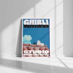 May include: A blue and white poster with the text "GHIBLI" in black letters and "STUDIO" in white letters. The poster also features a black cat and a white cat sitting on a red tiled roof.