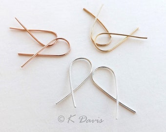 May include: Three pairs of earring hooks in different metal finishes: rose gold, gold, and silver. The hooks are simple and delicate, with a curved shape.