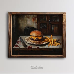 May include: A framed painting depicts a burger with melted cheese on a plate, french fries, and a knife on a table. The burger has a sesame seed bun. The table has red splatters. The background shows a cabinet and a dark appliance.