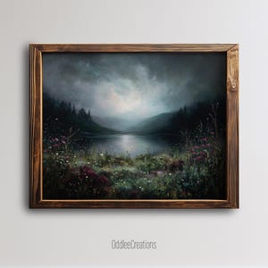 Pode incluir: Pintura de paisagem emoldurada que retrata uma serena cena lacustre sob um céu nublado e dramático. A obra de arte apresenta uma moldura de madeira escura e um primeiro plano de flores silvestres em tons de rosa e branco. O nome do artista, OddleeCreations, é visível.