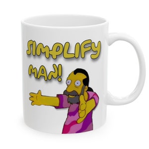 Peut inclure: Une tasse en céramique blanche avec un personnage de dessin animé jaune avec une barbe et une moustache. Le personnage porte une chemise rose et violette et pointe vers la gauche. Le texte "SIMPLIFY MAN!" est écrit en jaune au-dessus du personnage.
