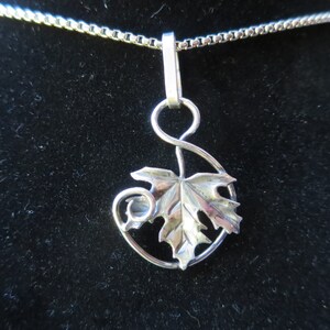 Peut inclure: Un collier avec un pendentif en argent repr&eacute;sentant une feuille d&eacute;taill&eacute;e avec une tige enroul&eacute;e. Le pendentif est attach&eacute; &agrave; une cha&icirc;ne en argent.