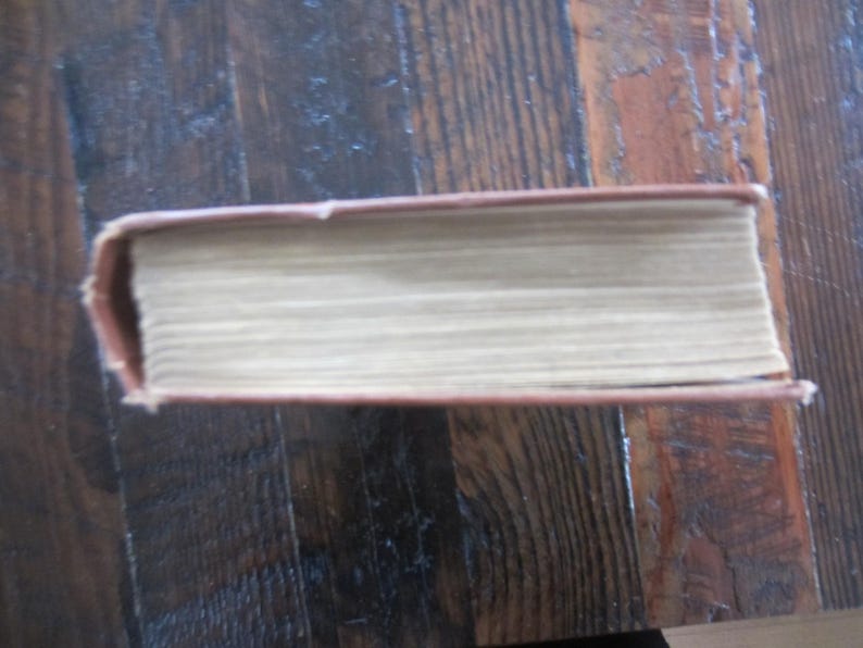 Puede incluir: Un libro de tapa dura marr&oacute;n con lomo blanco y una cubierta texturizada.