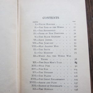 Puede incluir: Un libro titulado "The Virginian" de Owen Wister. La p&aacute;gina de contenido del libro enumera los cap&iacute;tulos y sus n&uacute;meros de p&aacute;gina correspondientes.