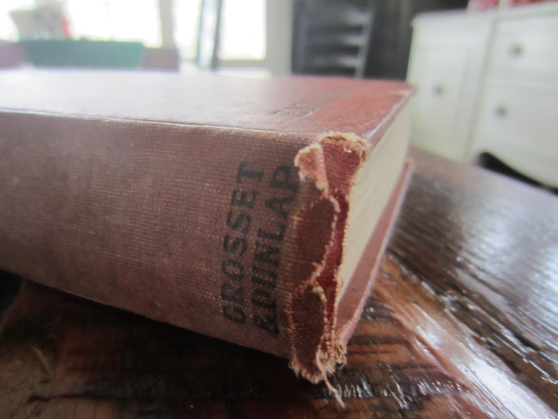Puede incluir: Primer plano de un libro marr&oacute;n con el texto "Grosset & Dunlap" impreso en el lomo.